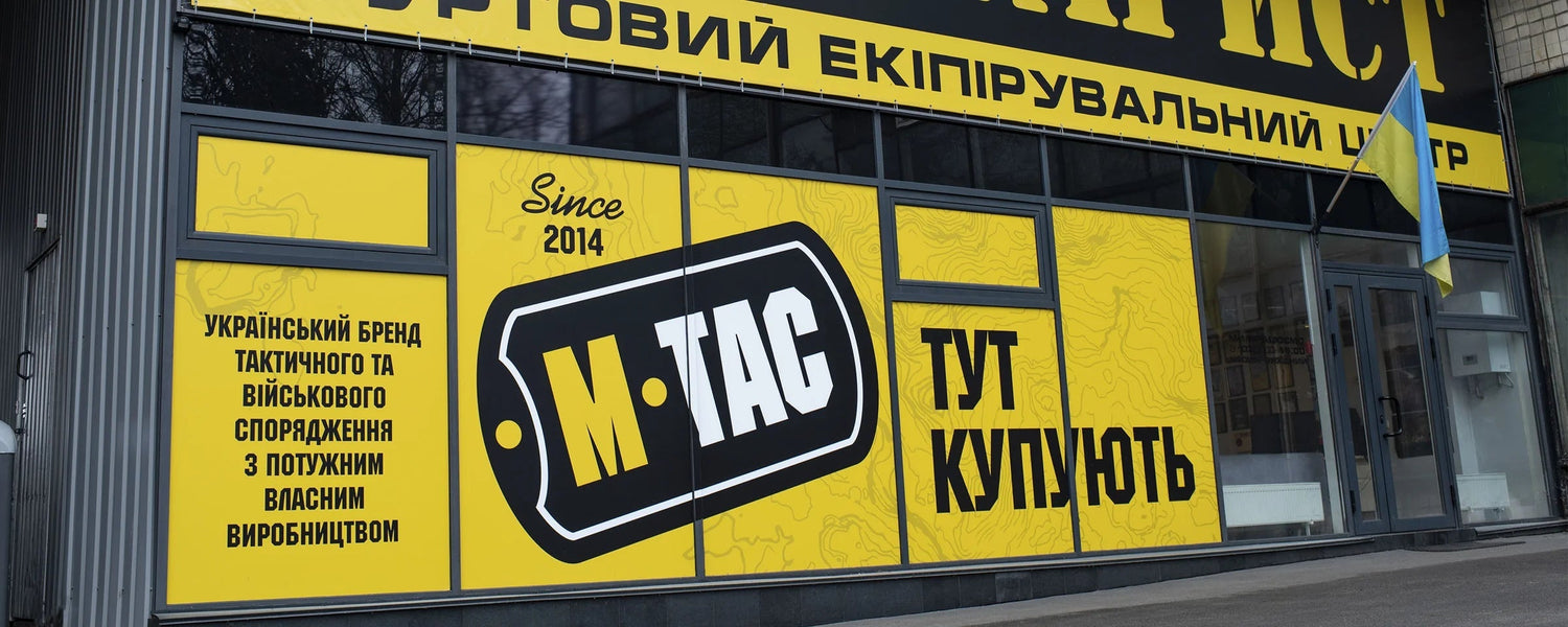 An M-TAC storefront in Ukraine with the company logo and a Ukrainian flag