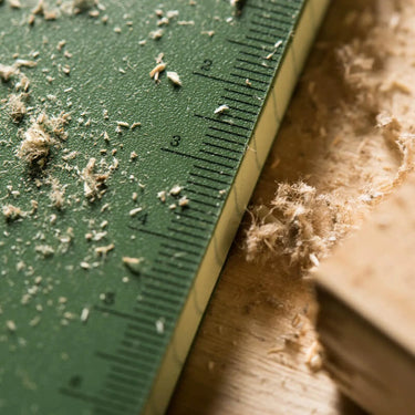 Green Rite in the Rain side spiral notebook with ruler markings, covered in sawdust.