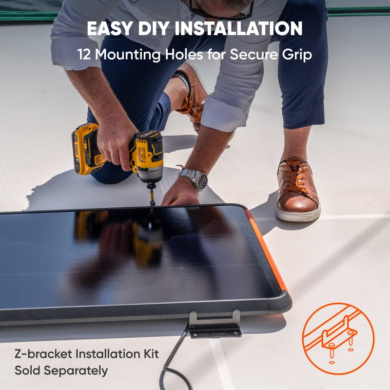 Man installing a black Jackery SolarSaga 100 Prime solar panel with orange trim using a drill and Z-bracket.