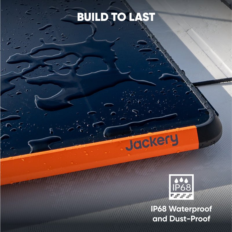 Jackery SolarSaga 100 Prime solar panel, dark blue with orange trim, covered in water droplets, showing IP68 rating.