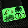 Glow-in-the-dark green silicone divider in a survival tin, organizing small parts like watch faces and rings.