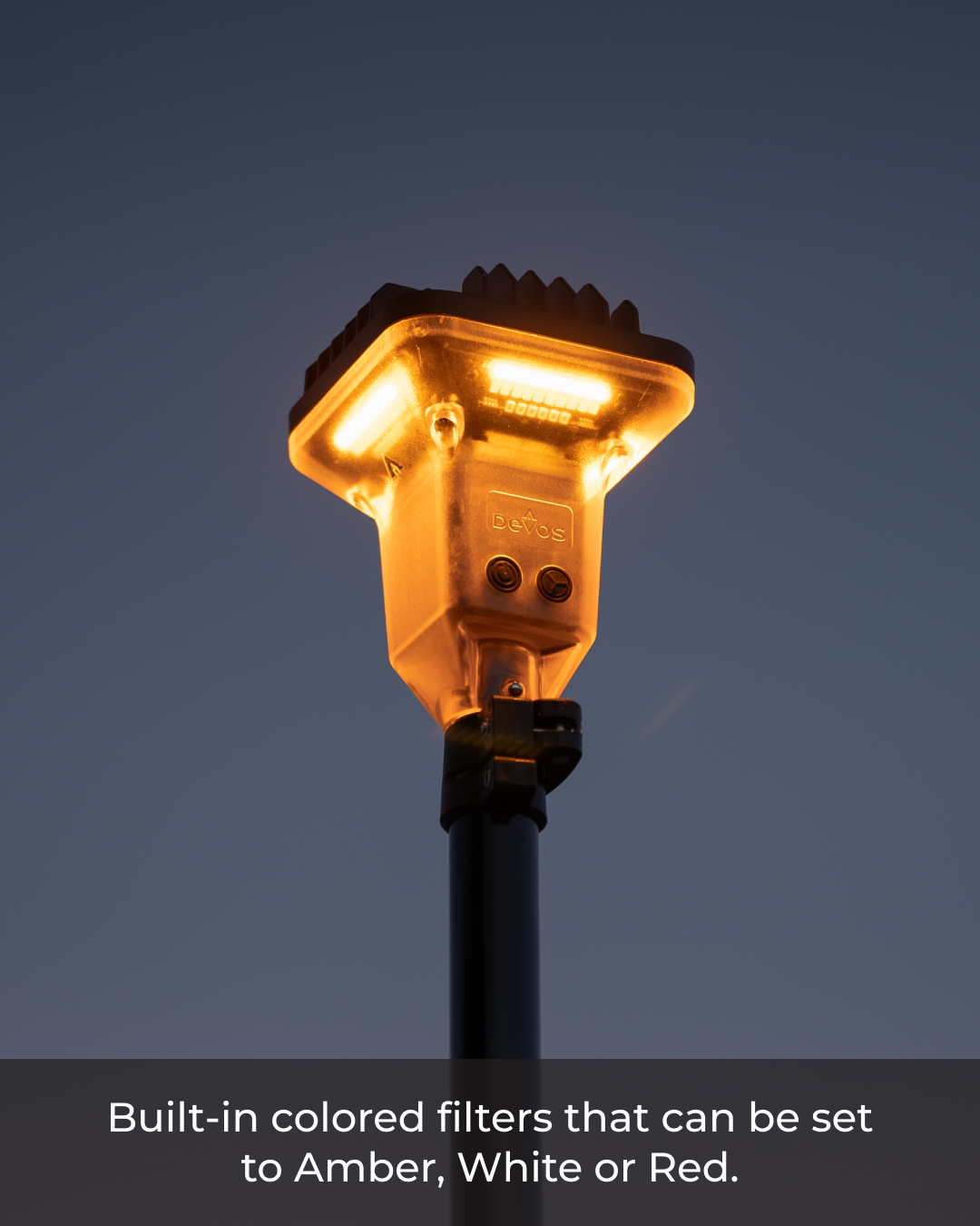 Devos LightRanger 2000 unit emitting amber light from its square, black-accented head on a dark pole.