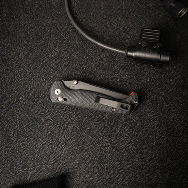 Shadow Black Dropwing folding knife with textured G10 handle, titanium clip, and red accents.