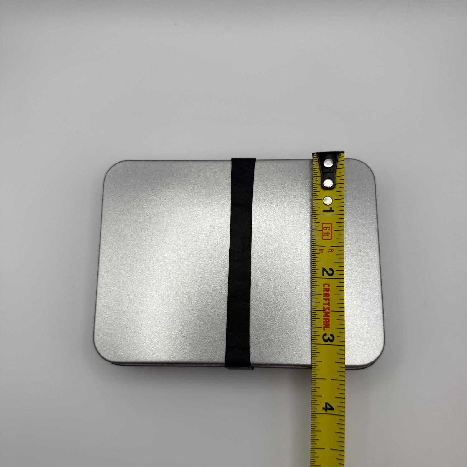 Compact silver metal INCOG emergency sustainment kit with a black band, measured at 3.75 inches long.