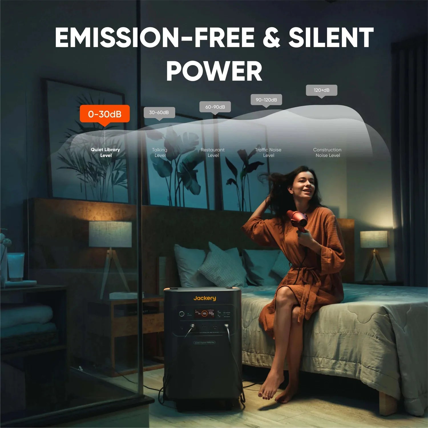 Jackery Explorer 5000 Plus portable power station, dark gray, charging in a bedroom with a woman drying her hair.