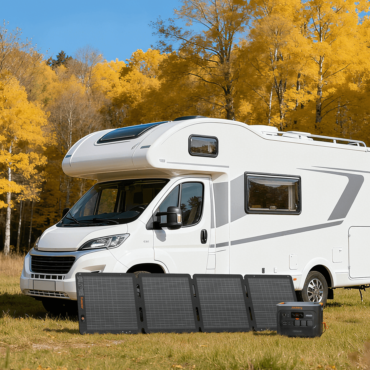 Jackery SolarSaga 100 Air solar panels and power station in front of a white RV with autumn trees.