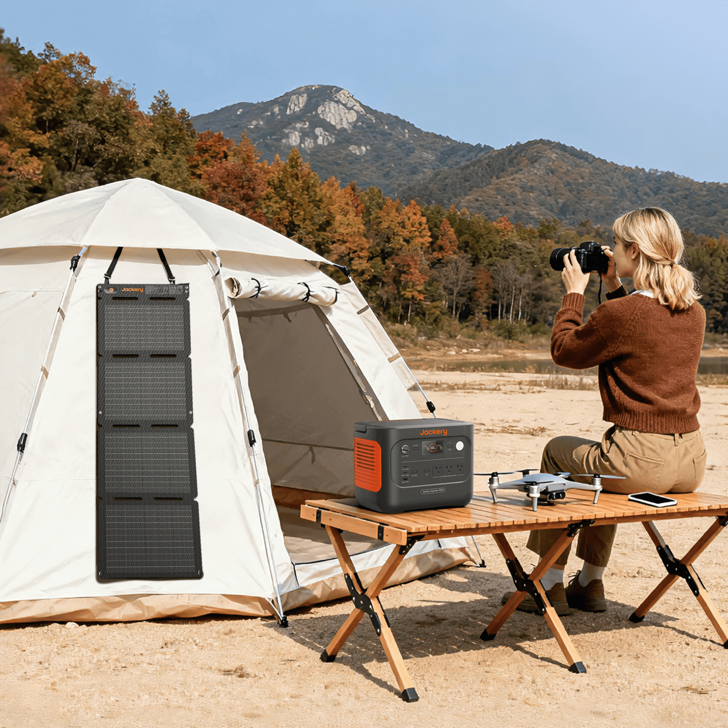 Jackery SolarSaga 40 Air solar panel hanging on a white tent, powering a black and orange power station.