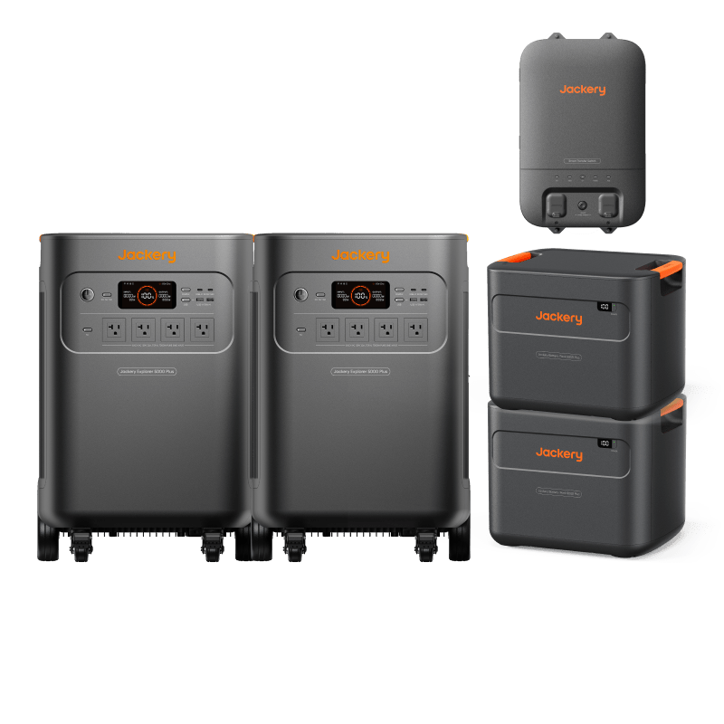 Jackery Whole-Home Backup Kit 5000 Plus with two gray portable power stations, two stacked battery packs, and a smart transfer switch.