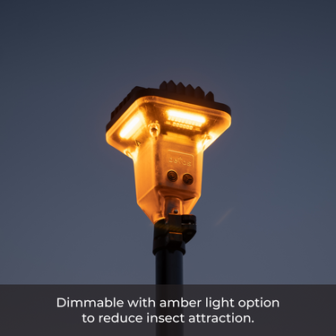 Devos LightRanger 2000 telescoping LED area light emitting warm amber light against a dark sky.