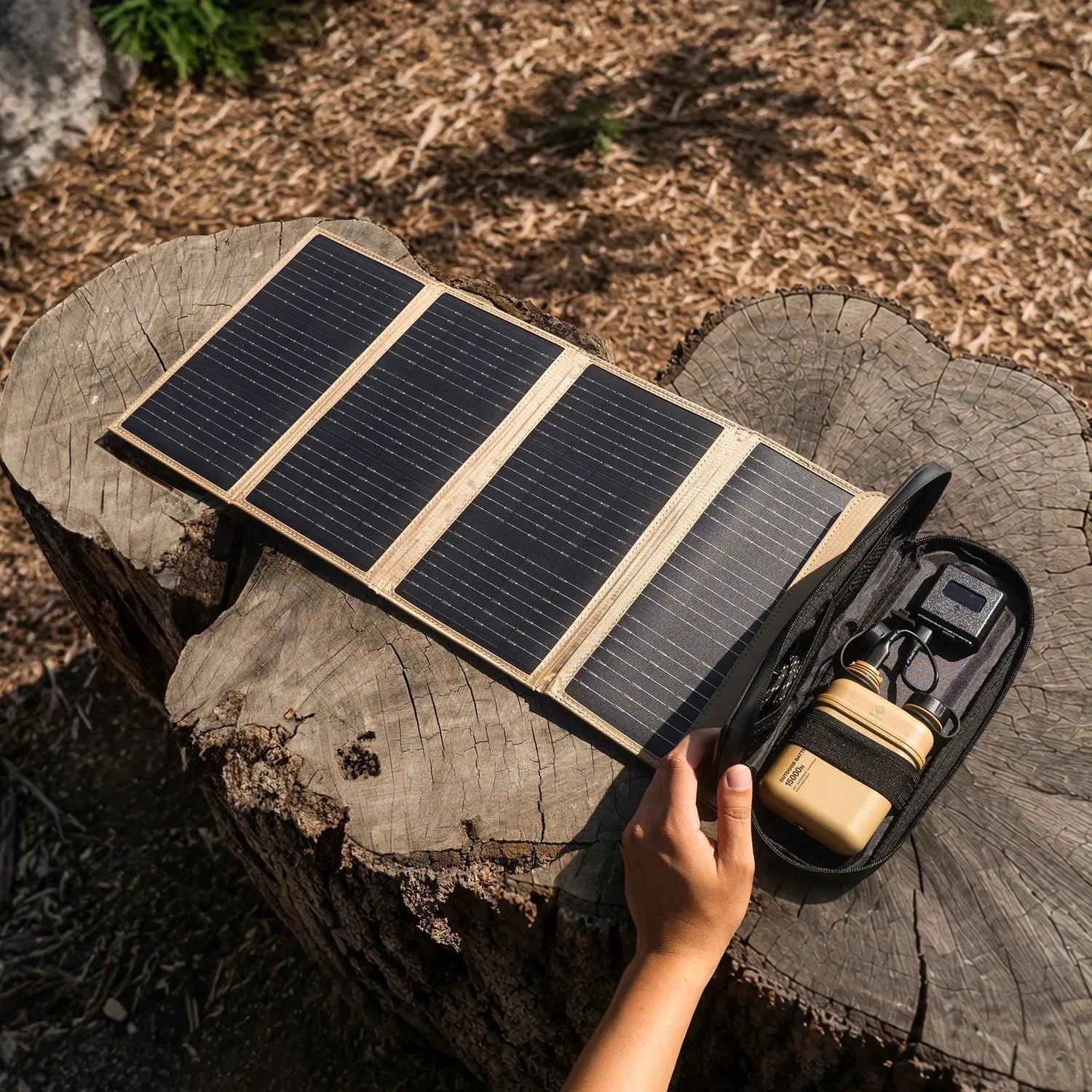 NESTOUT 4-panel solar charger with black monocrystalline cells and tan fabric, next to a tan battery pack.