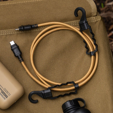 Tan braided USB-C charging cable with black connectors and integrated carabiner hooks on a tactical bag.