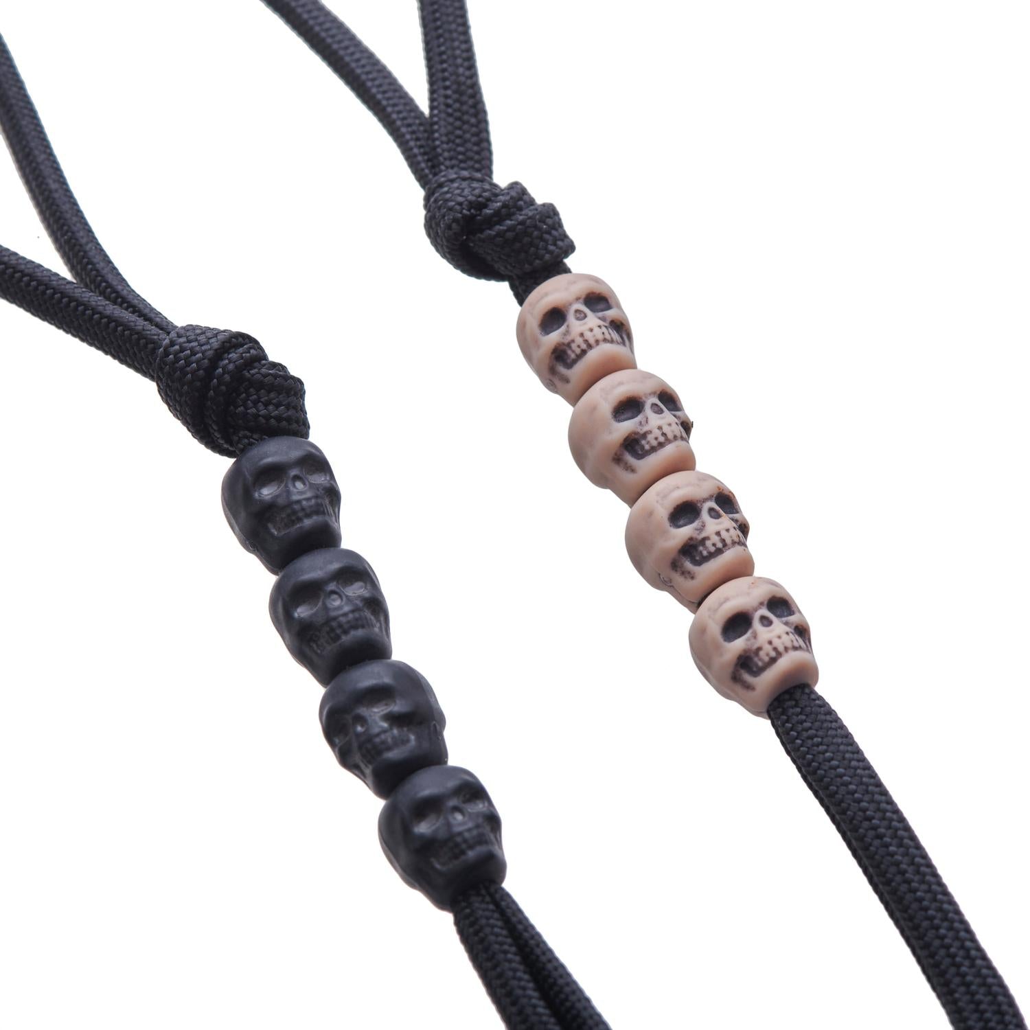 Two LYNX Survival Systems Pace Counter Beads sets: one with black skull beads, one with tan skull beads, on black paracord.